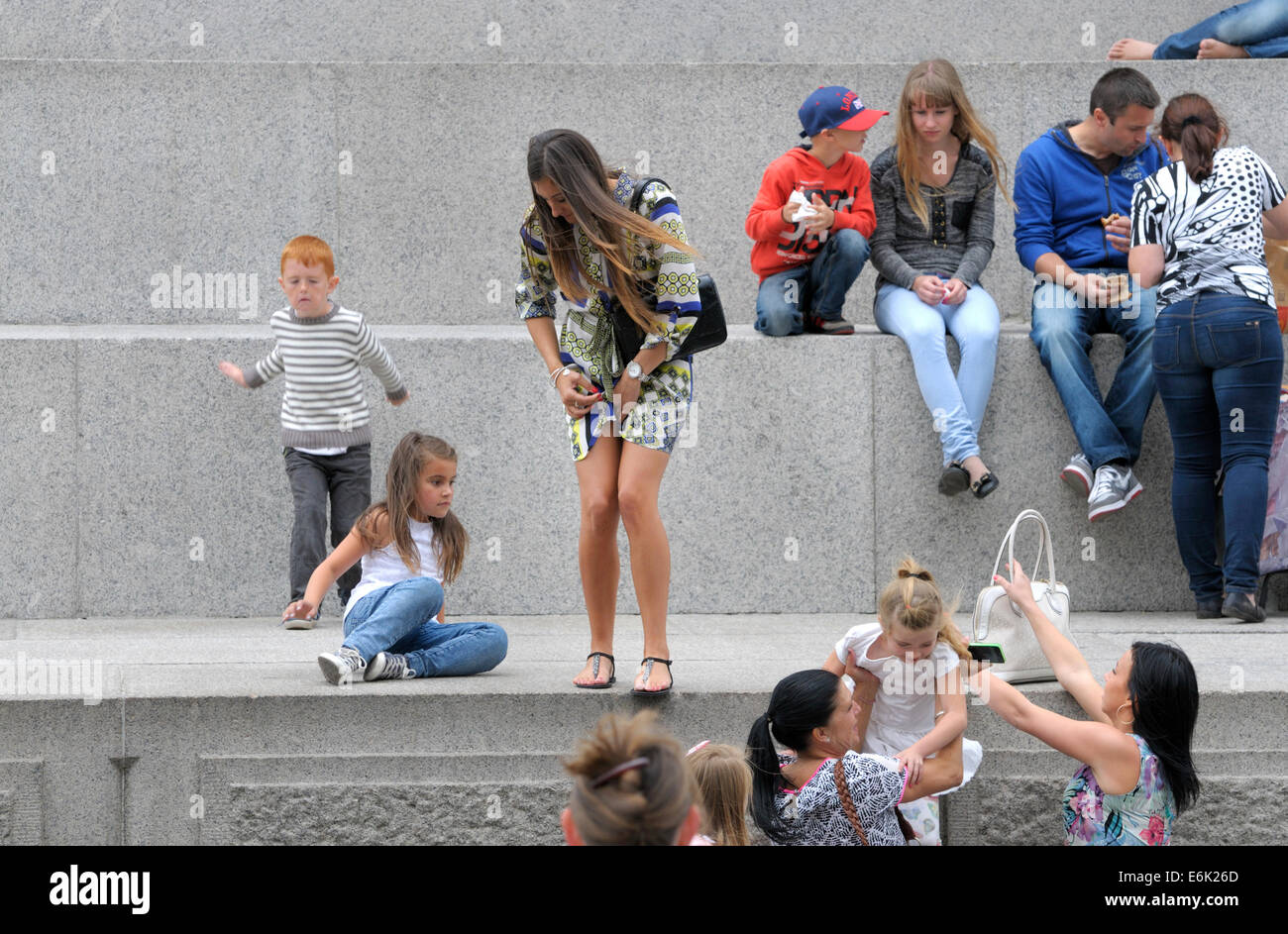 London, England, Vereinigtes Königreich. Frau mit einer jungen Familie Abstieg sorgfältig von der Basis der Nelsonsäule, Trafalgar Square Stockfoto