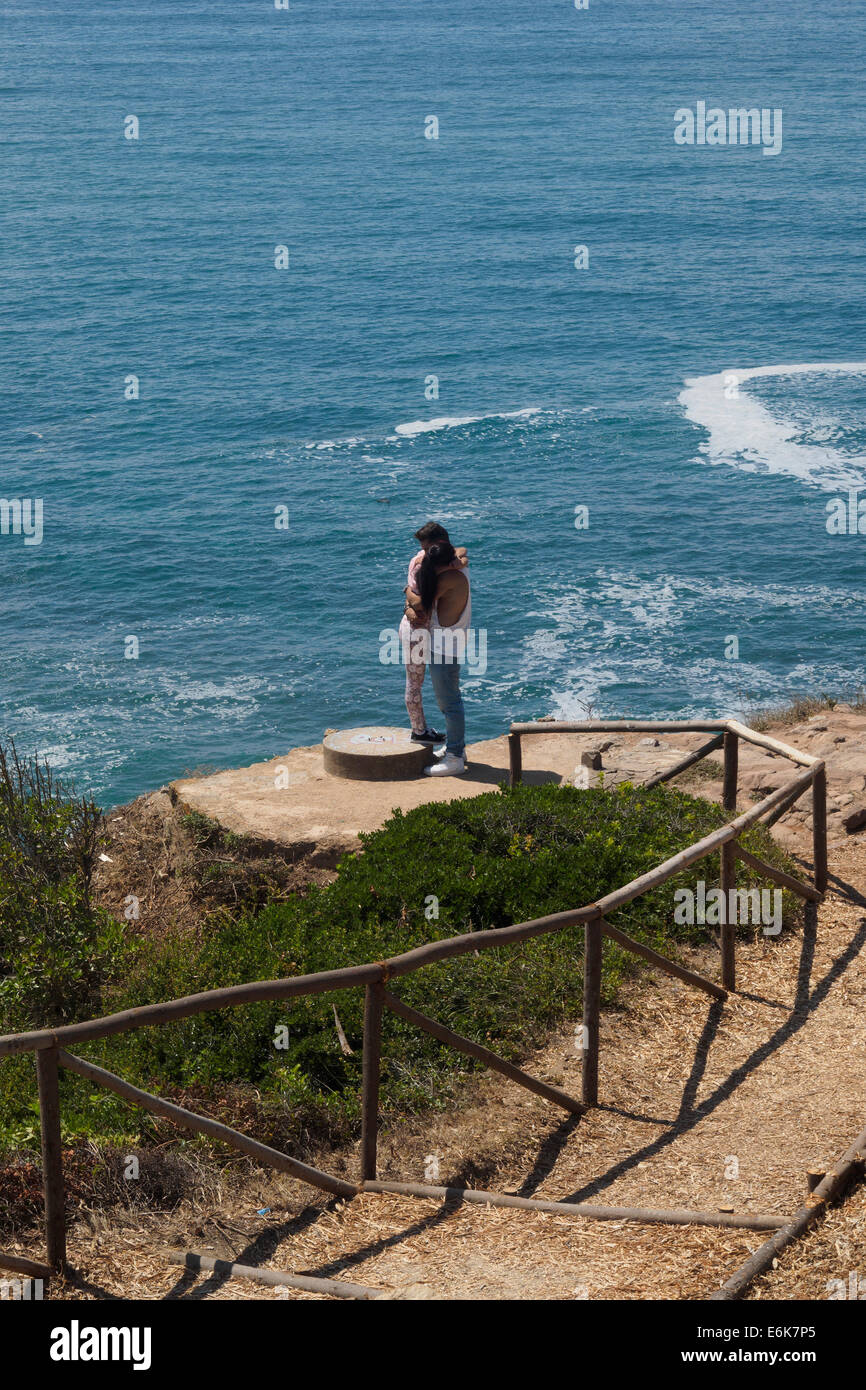 Junge Paar küssen auf einer Klippe am Meer Stockfoto