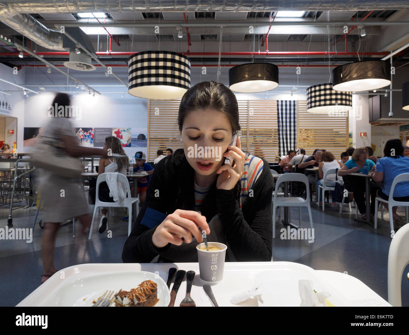 Frau trinkt Kaffee während des Gesprächs auf dem Handy Stockfoto