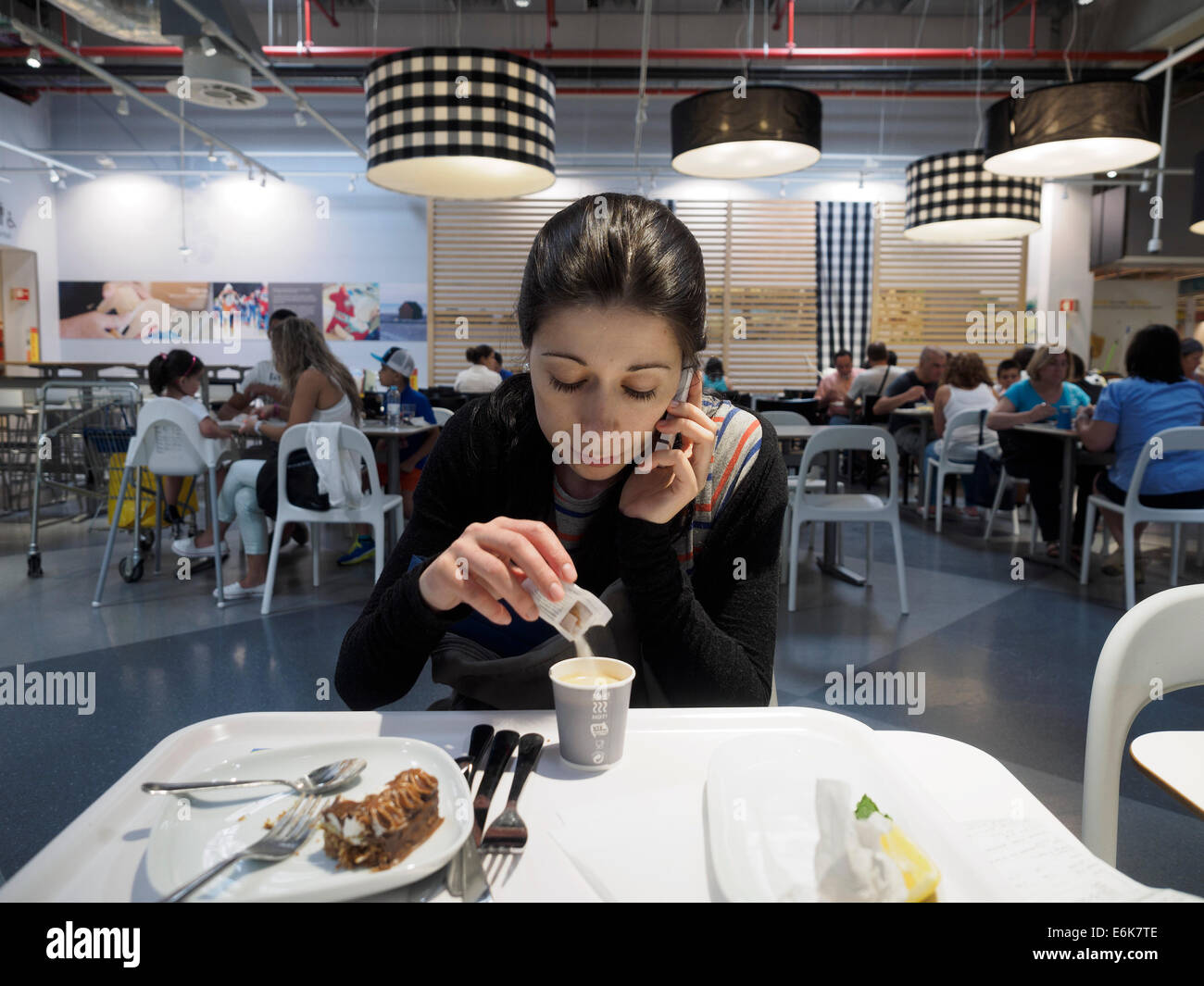 Frau trinkt Kaffee während des Gesprächs auf dem Handy Stockfoto