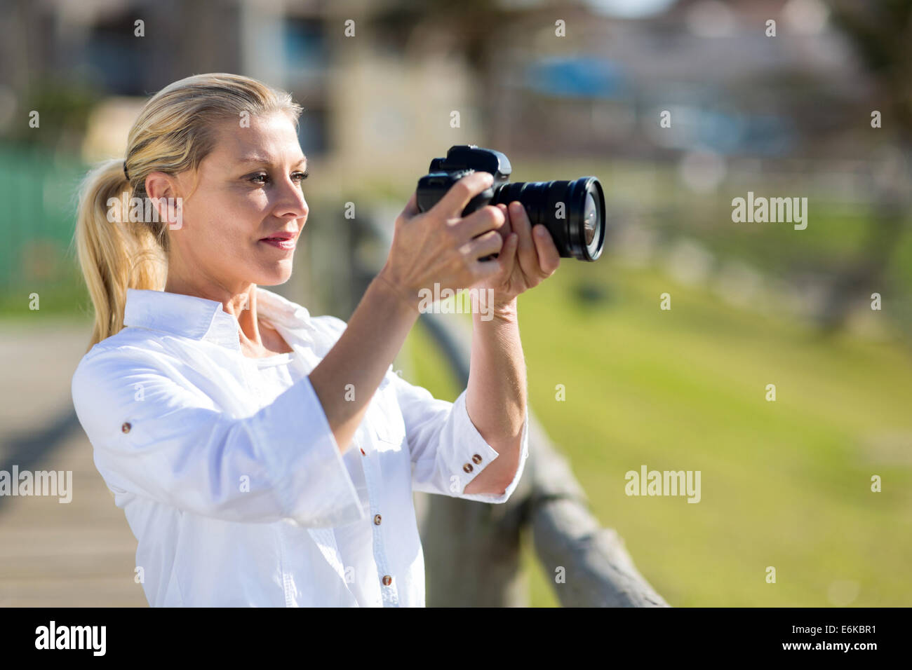 mittlere gealterte Frau fotografieren im Freien mit DSLR-Kamera Stockfoto