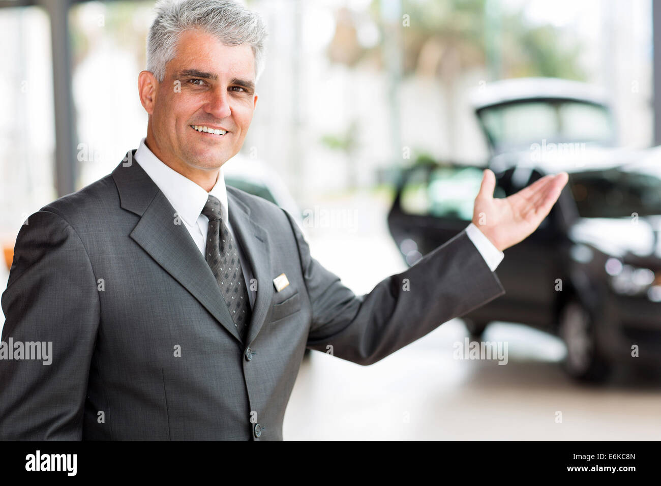schöne ältere Fahrzeug Verkäufer Neuwagen im Showroom präsentiert Stockfoto