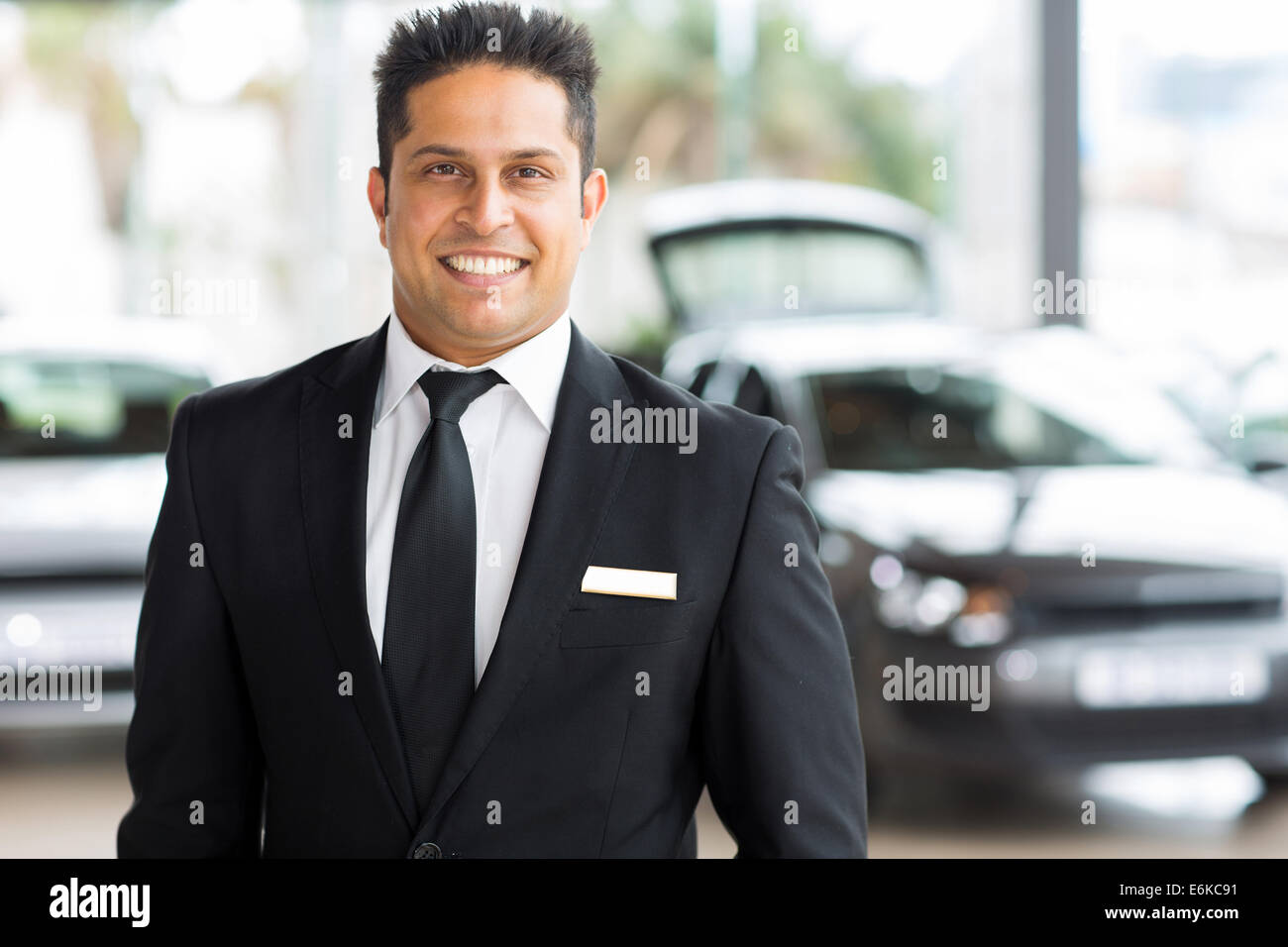 glückliche junge indische Autoverkäufer im showroom Stockfoto