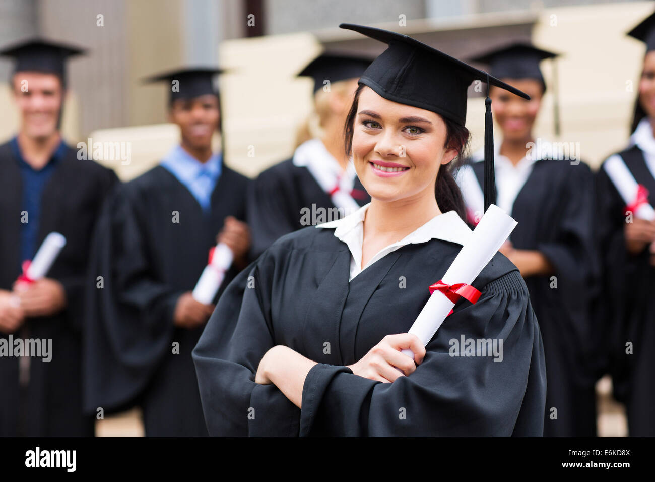 attraktive weibliche Absolventin hält ihr Diplom bei Abschlussfeier Stockfoto