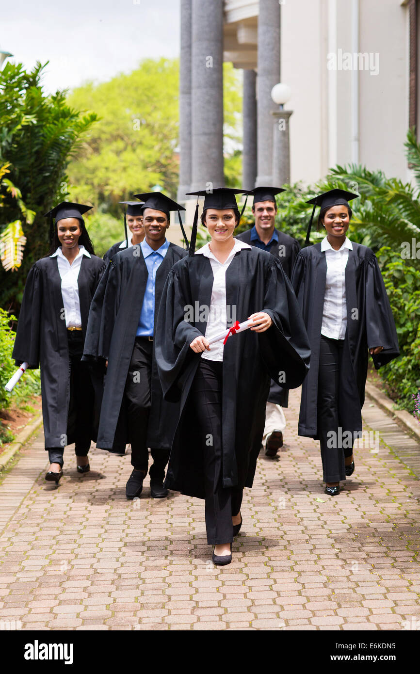Gruppe von glücklichen Absolventen zu Fuß zur Abschlussfeier Stockfoto