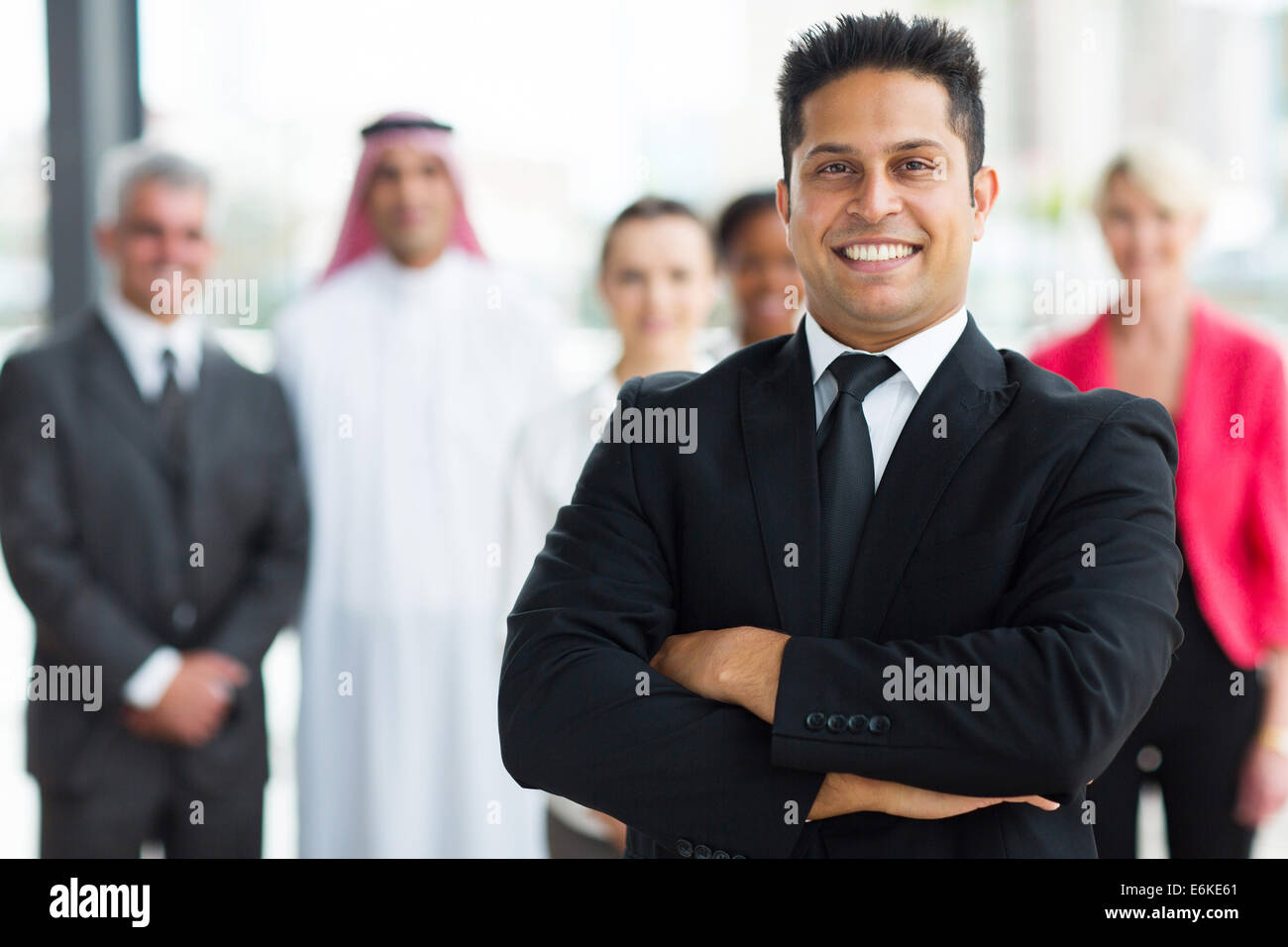 fröhliche junge indische Geschäftsmann mit Team auf Hintergrund Stockfoto