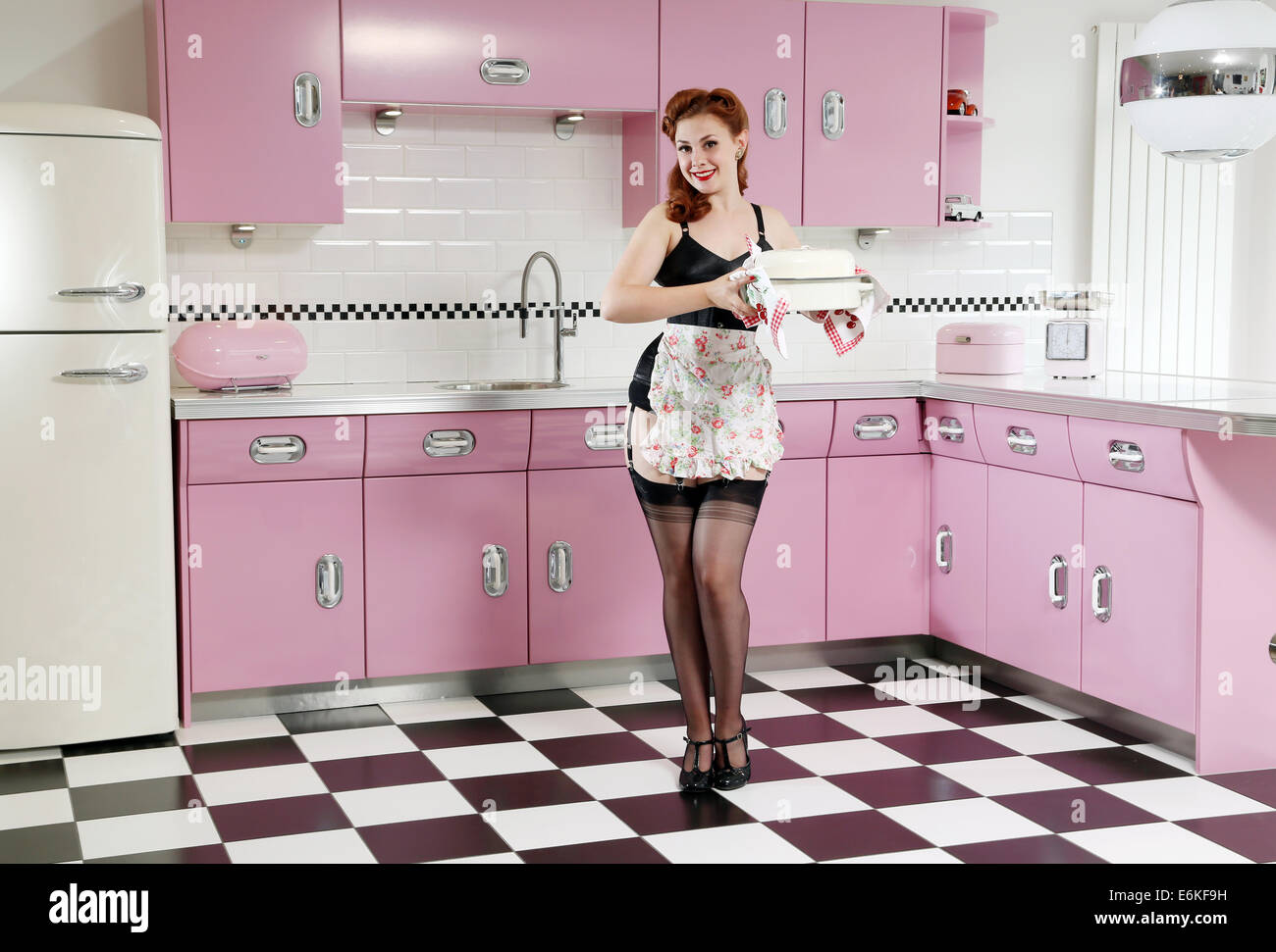 Frau in sexy Dessous steht in Vintage-Küche Stockfoto
