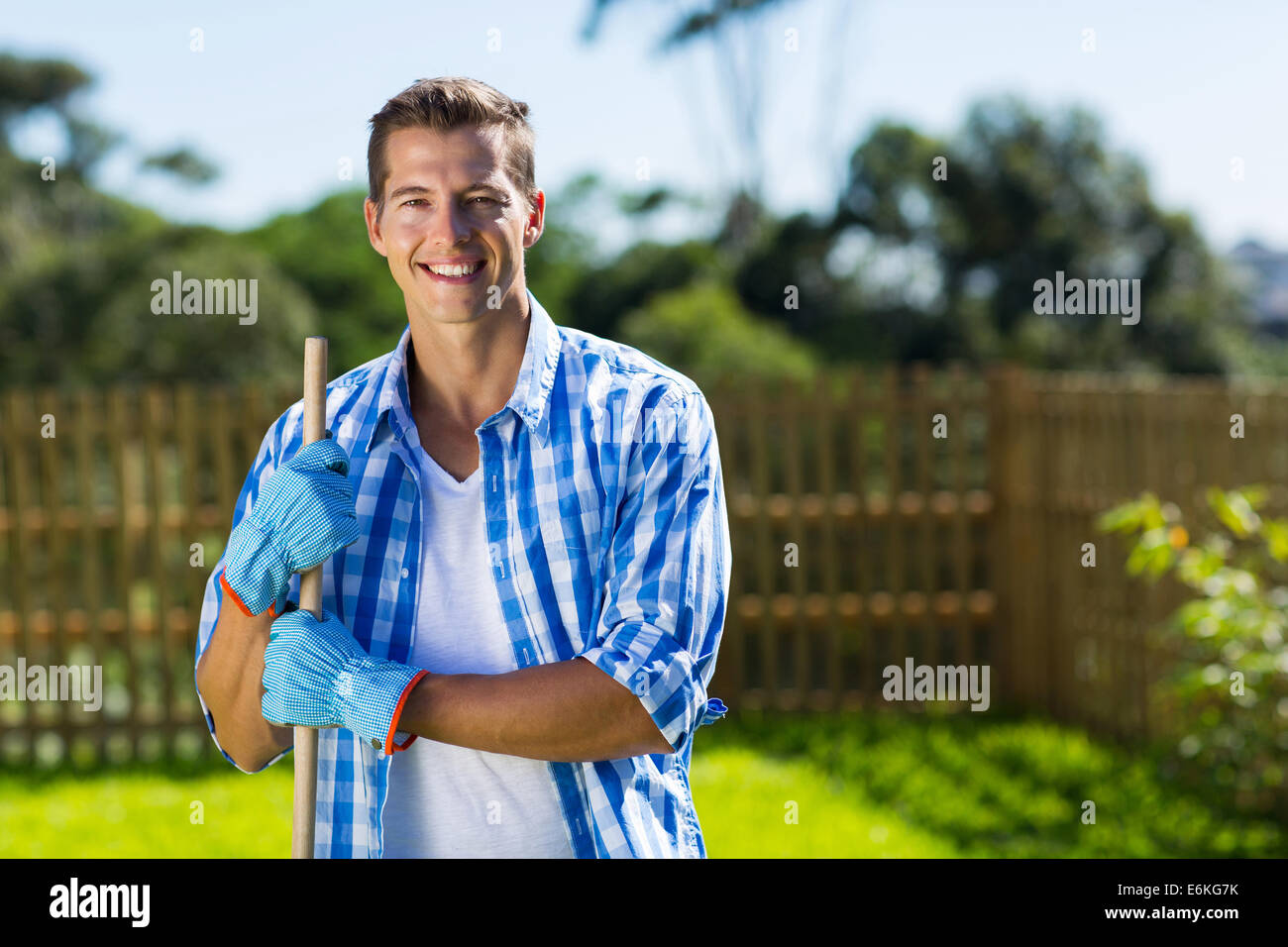 hübscher junger Mann Reinigung Hausgarten Stockfoto