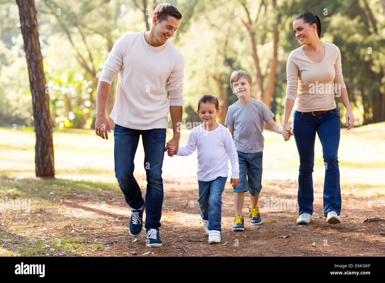 schöne junge Familie Hand in hand im Park zu Fuß Stockfoto