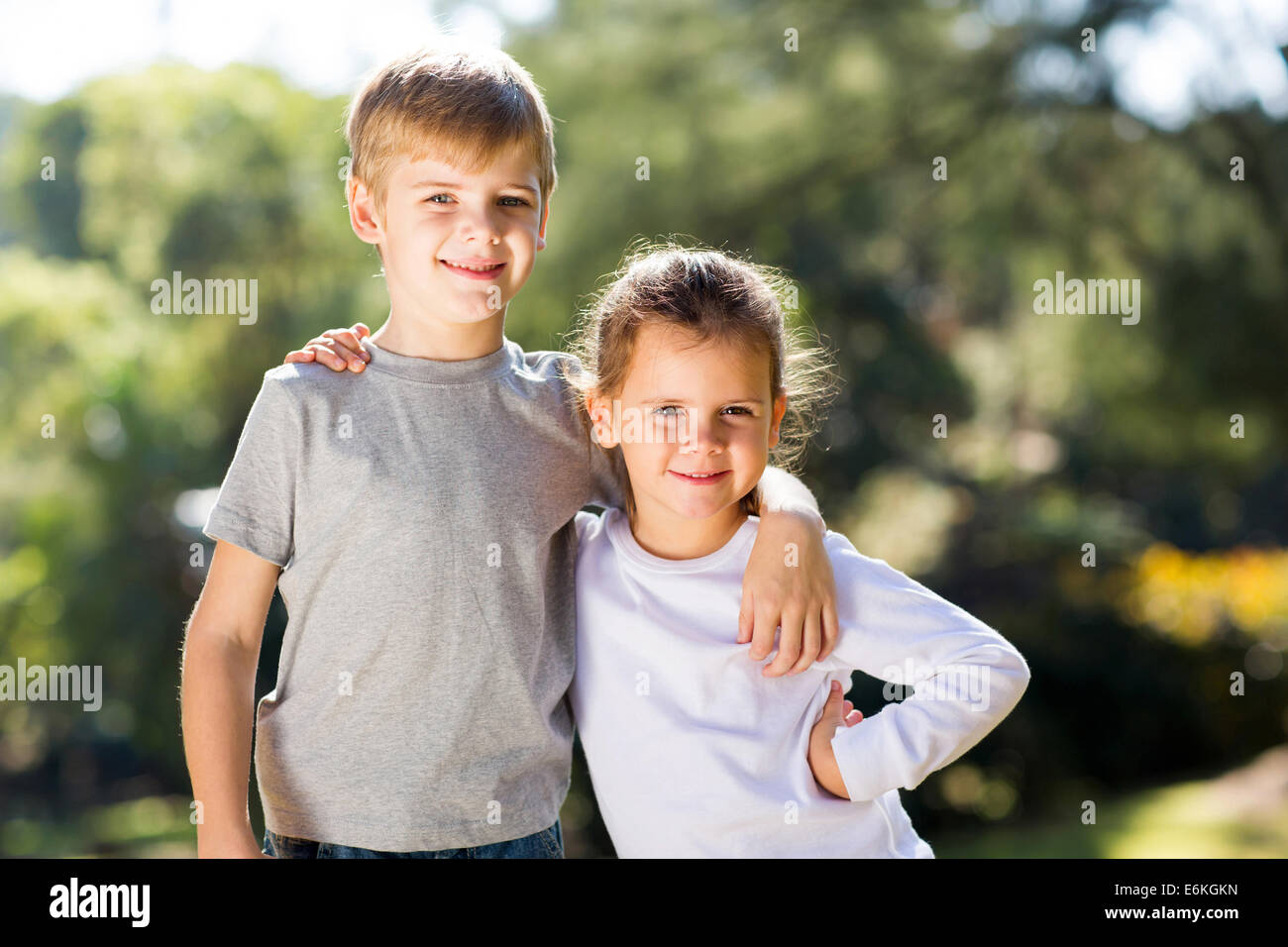 glückliche kleine Schwester und Bruder zusammen im freien Stockfoto