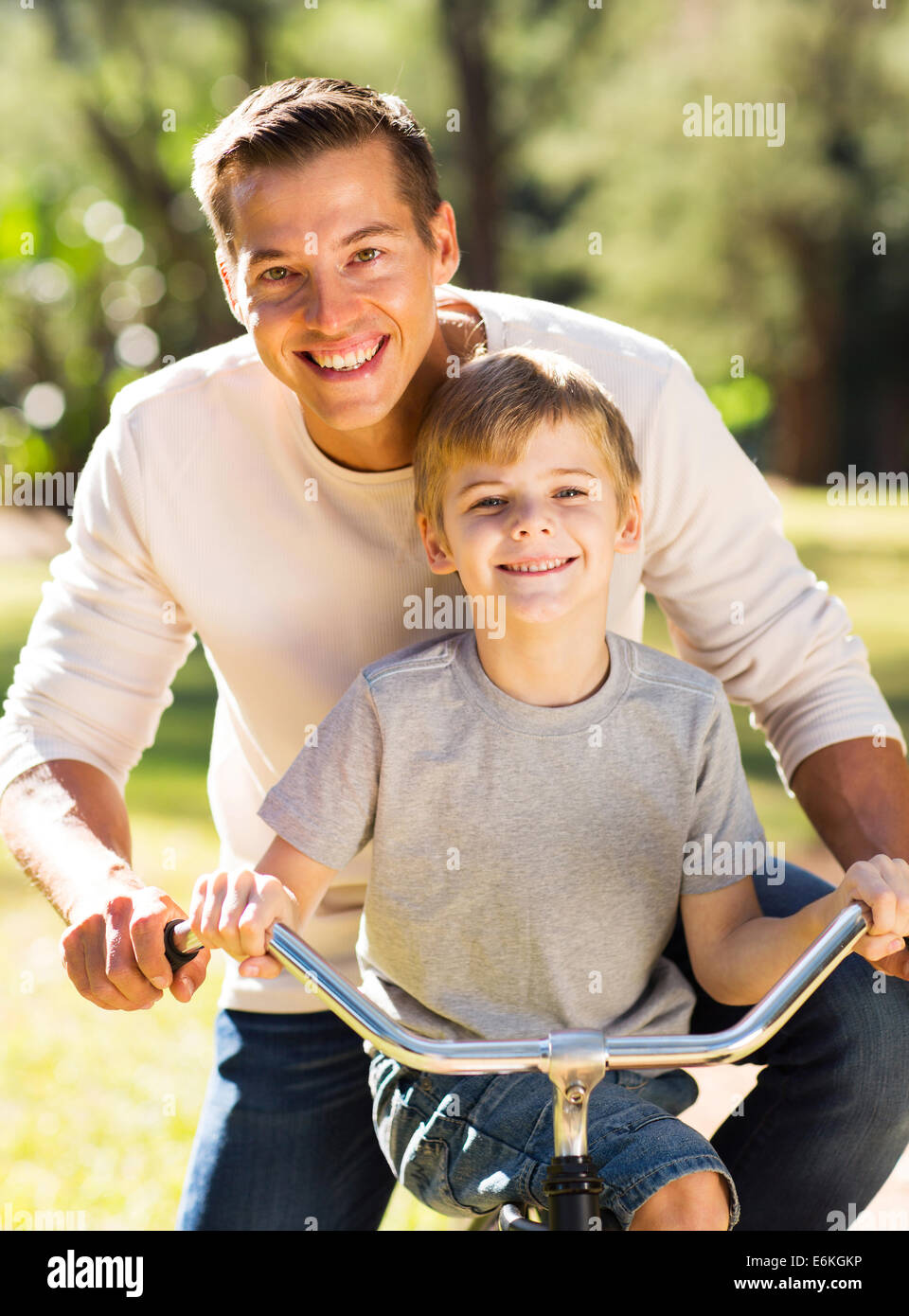 glücklicher Vater und Sohn mit dem Fahrrad gemeinsam im freien Stockfoto