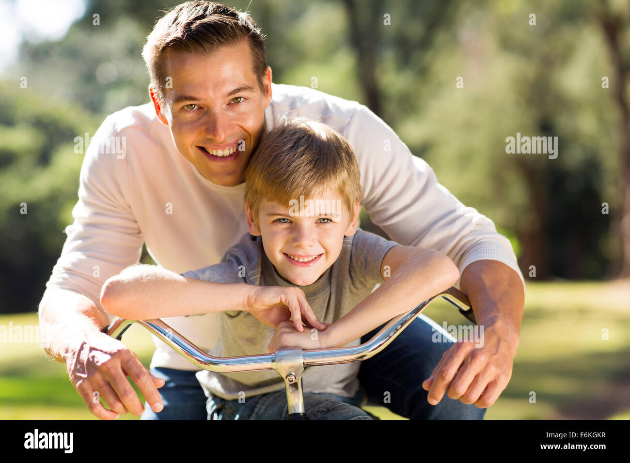 Porträt der glückliche junge Vater und Sohn auf dem Fahrrad Stockfoto