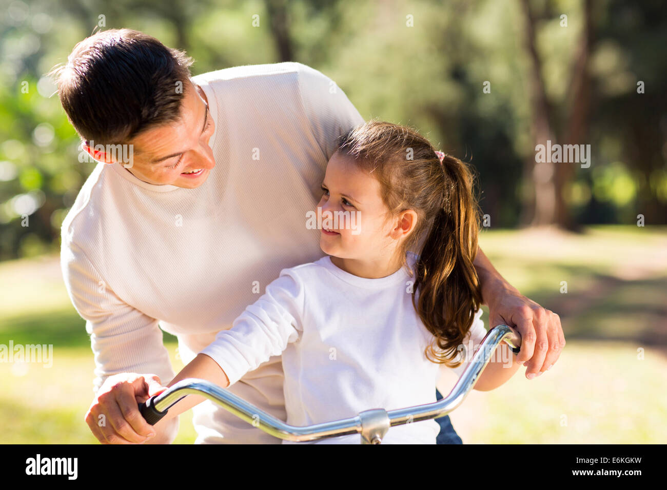 glückliche junge Vater Reiten Fahrrad mit seiner Tochter im freien Stockfoto