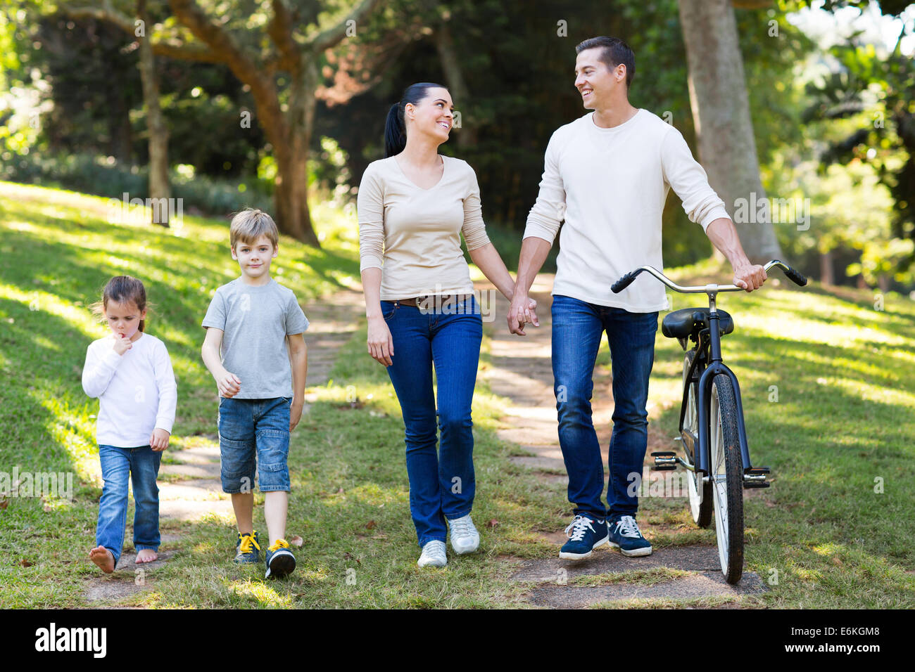 schöne junge Paar und Kinder zu Fuß draußen im park Stockfoto