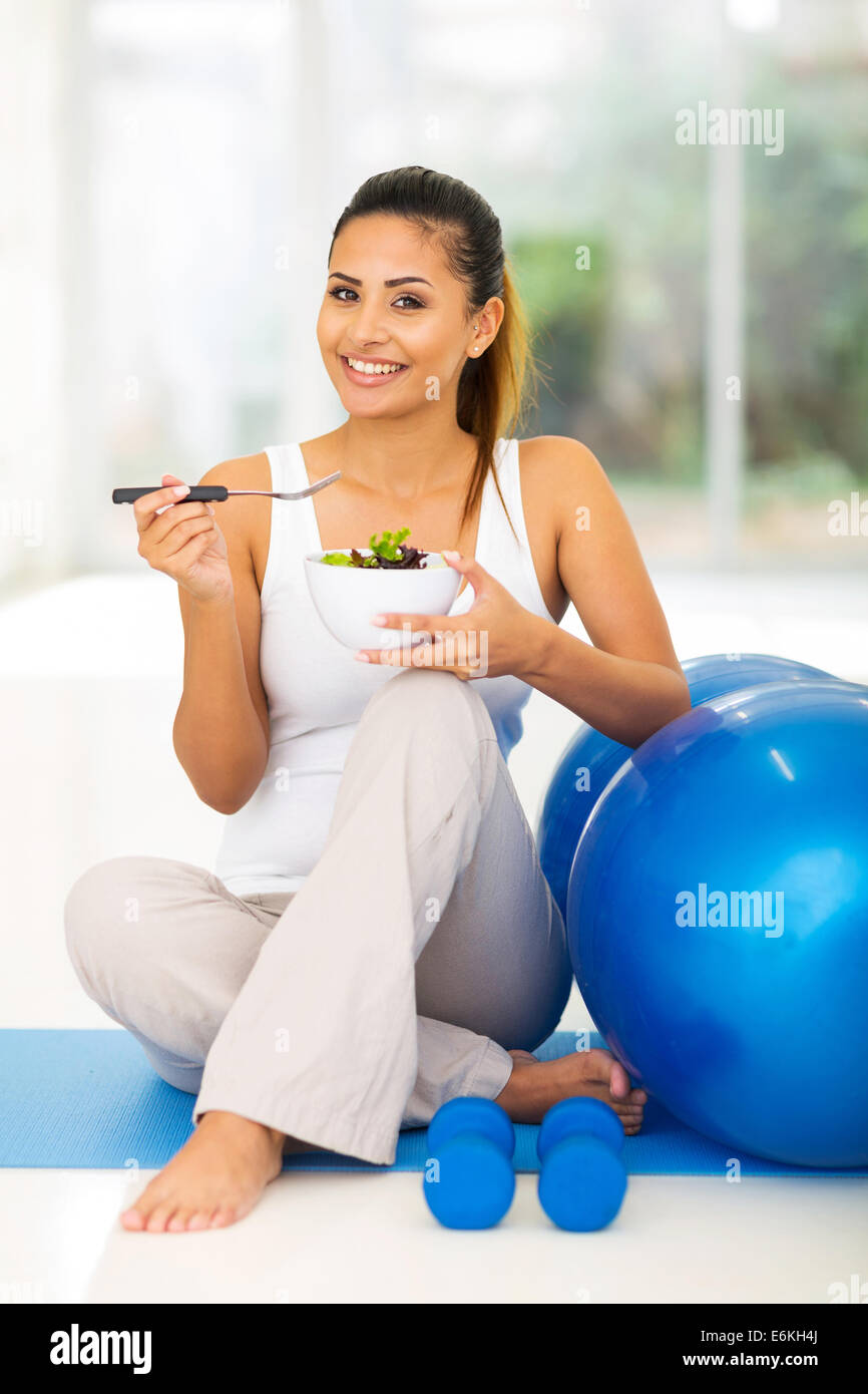 glückliche Frau genießen frische gesunde Salat sitzen auf Gymnastikmatte Stockfoto
