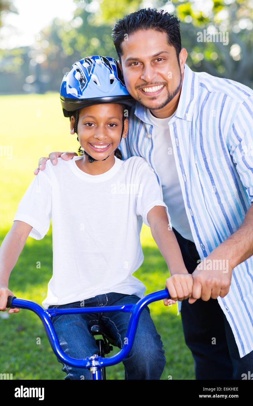 Indische Mädchen auf einem Fahrrad mit ihrem Vater neben ihr stehen Stockfoto