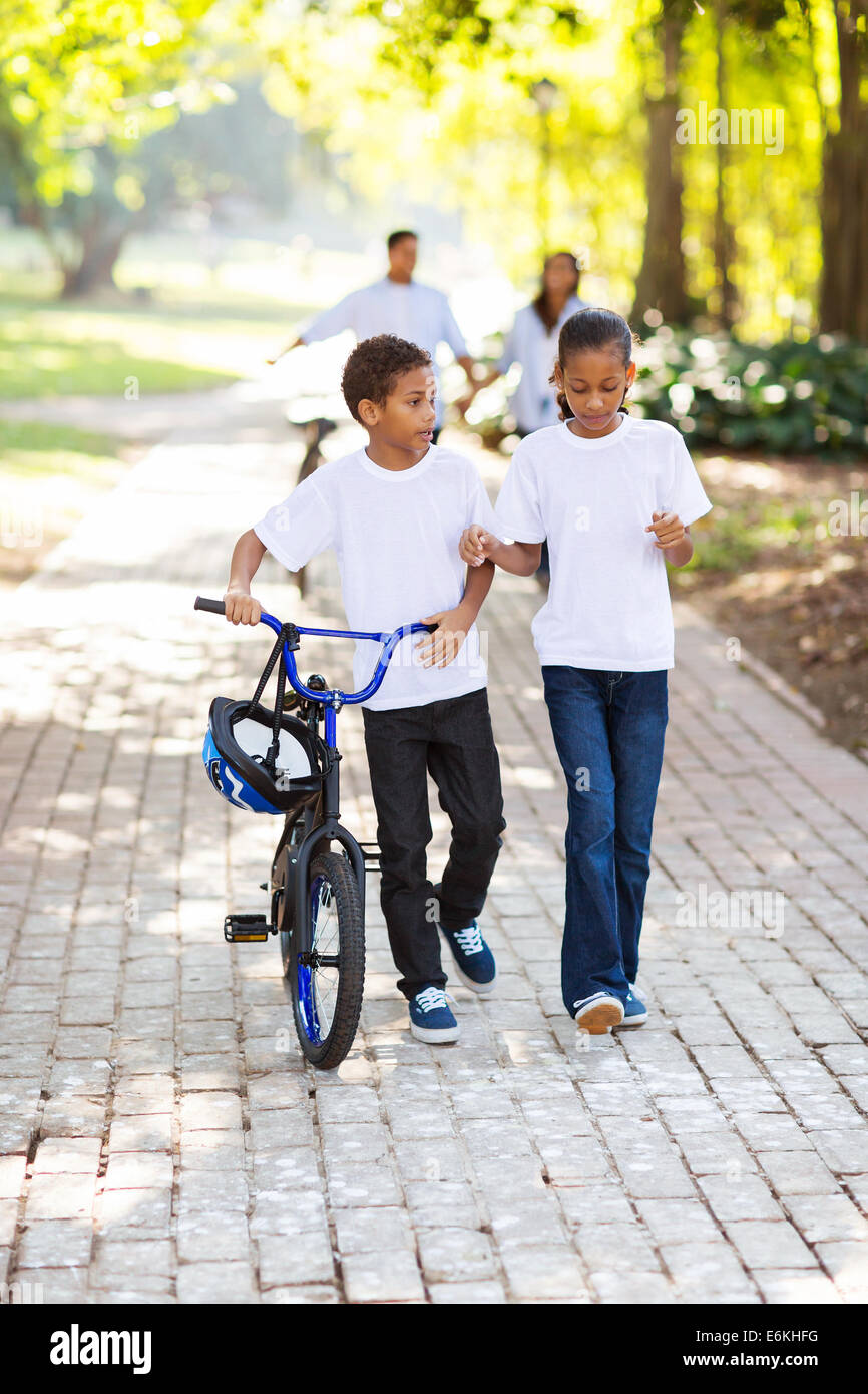 Kinder mit dem Fahrrad mit Eltern hinter im park Stockfoto