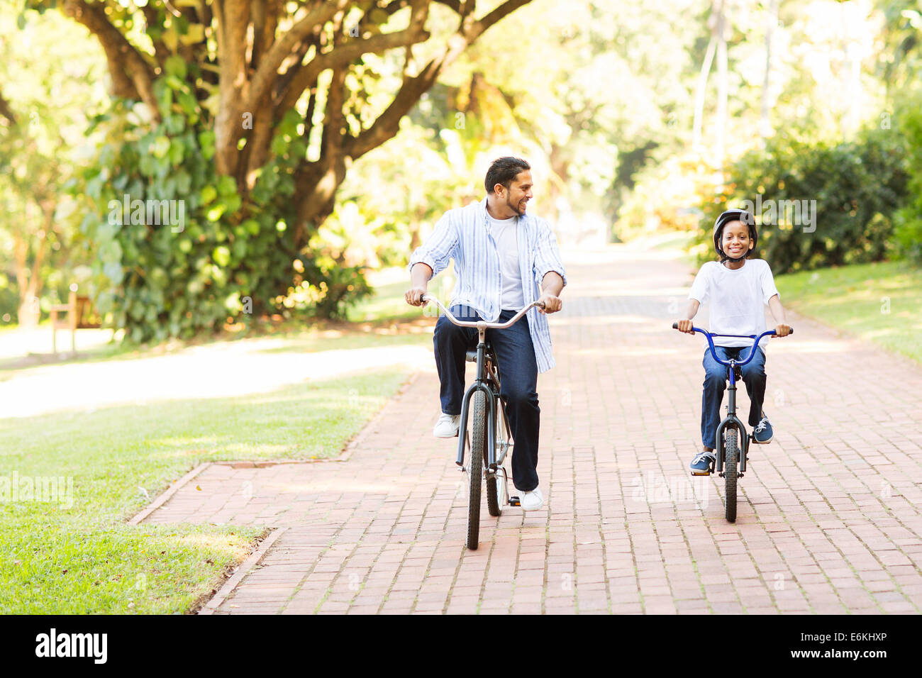 fröhlichen indische Vater und Tochter Reiten Fahrräder im park Stockfoto