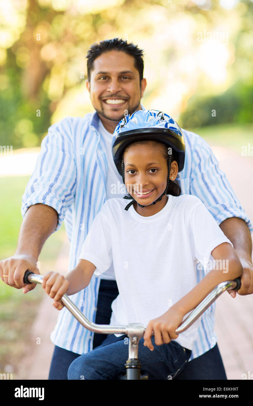 glücklich indischer Vater und Tochter im Freien auf einem Fahrrad Stockfoto