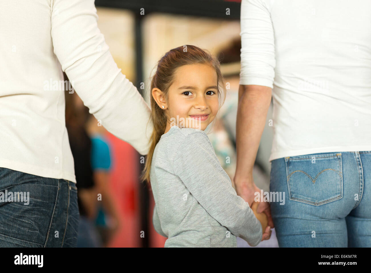 niedliche kleine Mädchen ihren Eltern Händchenhalten und Rückblick auf Flughafen Stockfoto