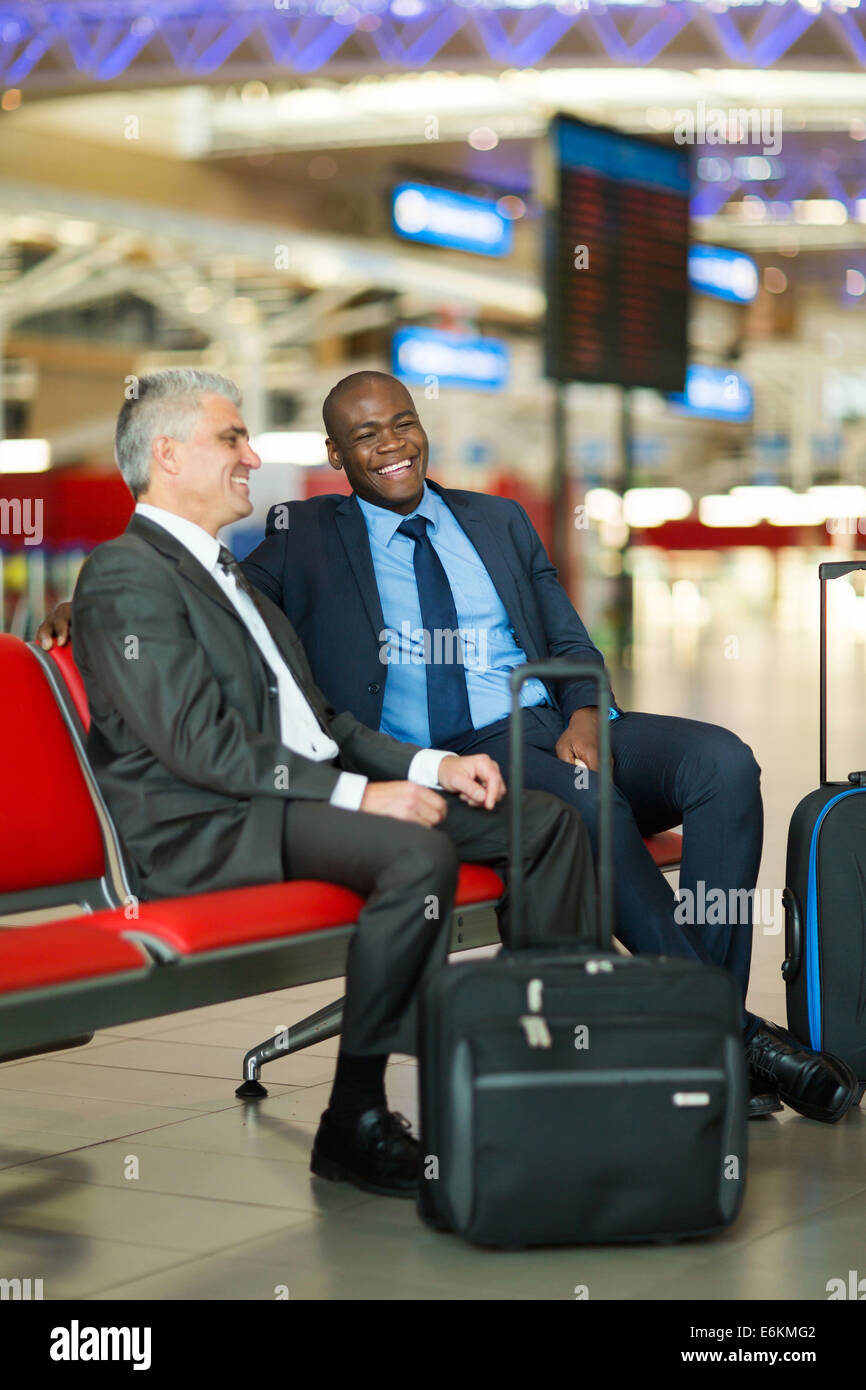 fröhliche Geschäftsreisende warten auf ihren Flug am Flughafen Stockfoto