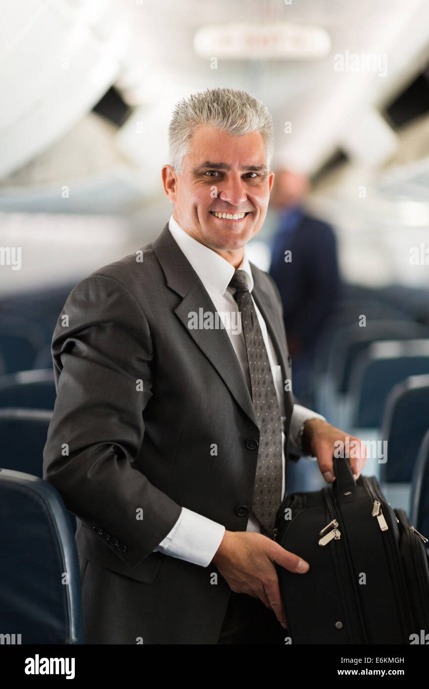 gut aussehende mittleren Alter Geschäftsmann Tragetasche in Flugzeug Stockfoto