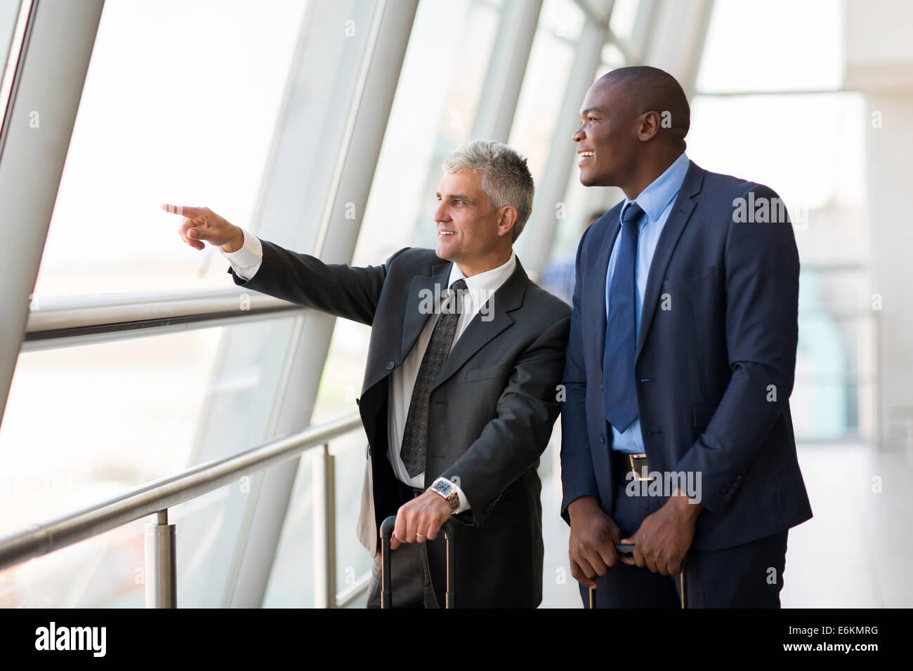 gut aussehende Geschäftsreisende zeigen am Flughafen Stockfoto