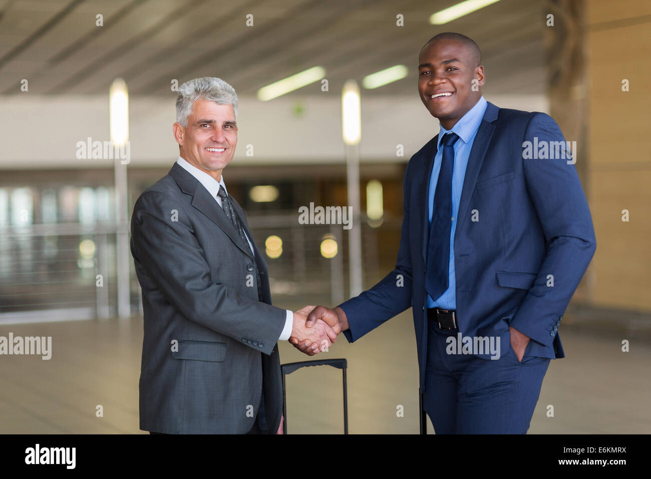 Porträt von Geschäftsreisenden, die Begrüßung am Flughafen Stockfoto
