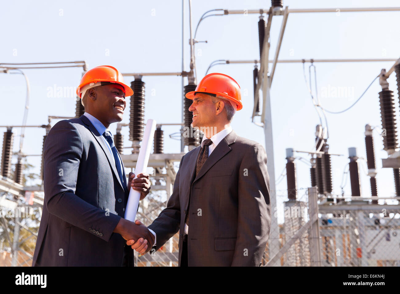 zwei fröhliche Geschäftsmann Handshaking in elektrische Unterstation Stockfoto