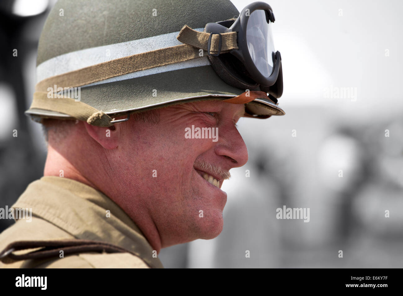 Armee-Mann mit Helm und Brille und einem großen Lächeln. Stockfoto