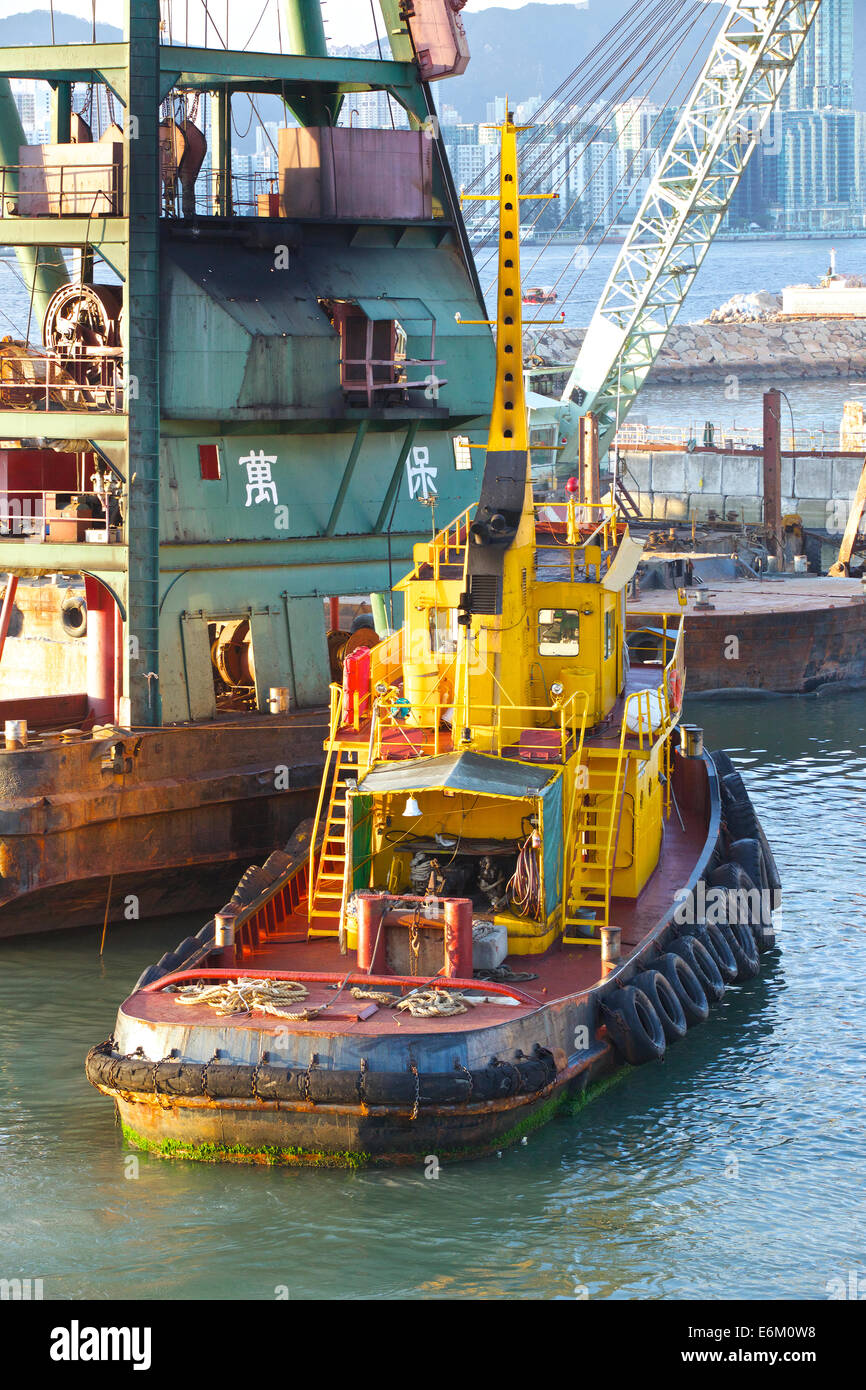 Schlepper bewegt sich ein Derrick Barge In der Causeway Bay Typhoon Shelter, Hong Kong. Stockfoto