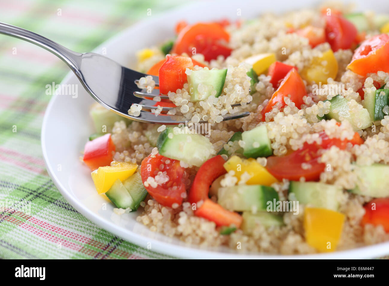 Vegan Quinoa Salat. Zutaten: Quinoa; rote Cherry-Tomaten, gelbe und rote Paprika, Gurke. Stockfoto