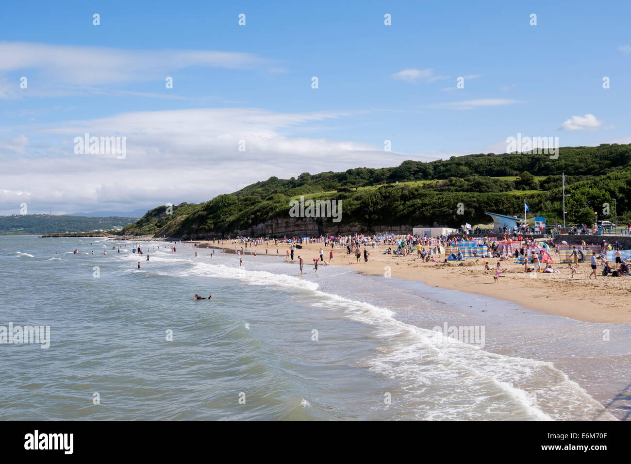 Baden im Meer am belebten Sandstrand bei Flut im Sommer nachmittags Pers. Benllech, Isle of Anglesey, Wales, UK, Großbritannien Stockfoto