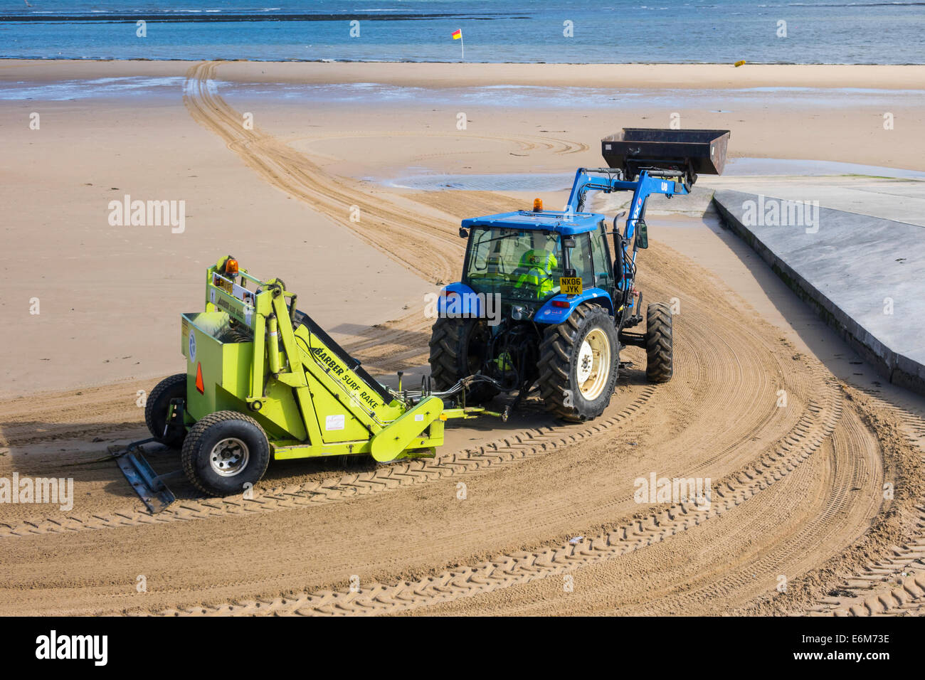 Badestrand Meer in Redcar gereinigt von den örtlichen Behörden über eine mechanische Traktor gezogen Maschine Arber Surf Rake Stockfoto