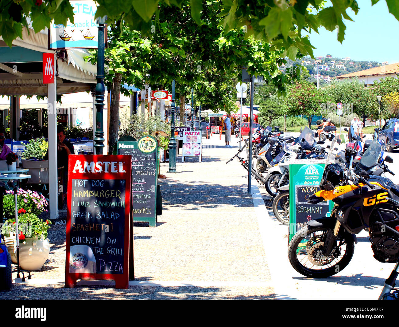 Bars und Motorräder direkt am Meer auf der Insel Skiathos auf den griechischen Inseln, Griechenland. Stockfoto