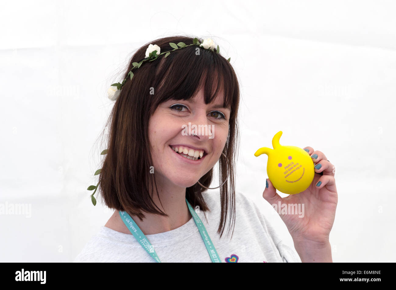eine lächelnde junge Frau an ihrem Charity-Stand an der siegreichen Festival 2014 Southsea England uk Stockfoto