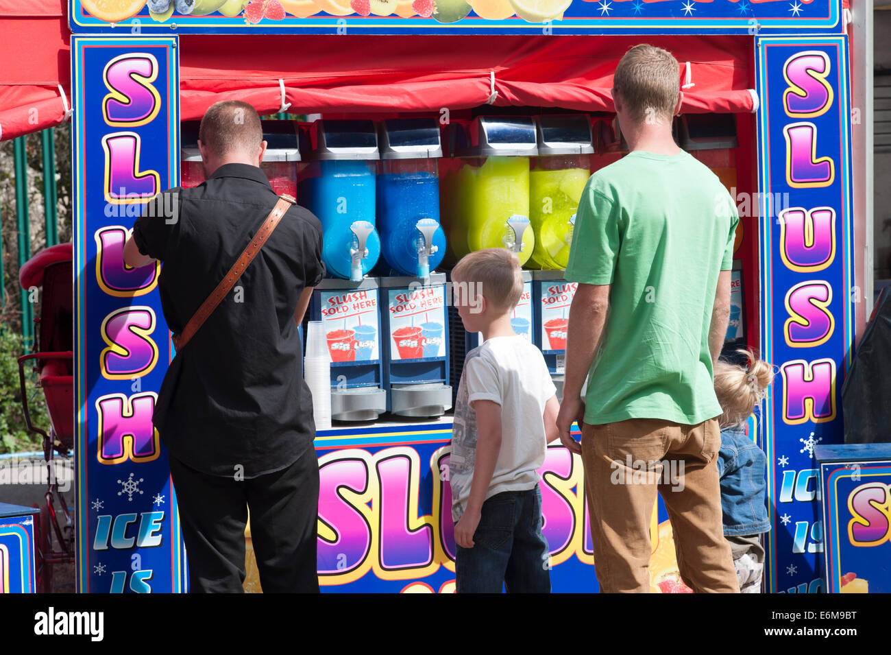 ein Mann kaufen Eis kalten Schneematsch trinkt für seine Kinder an die siegreichen Festival 2014 Southsea England uk Stockfoto