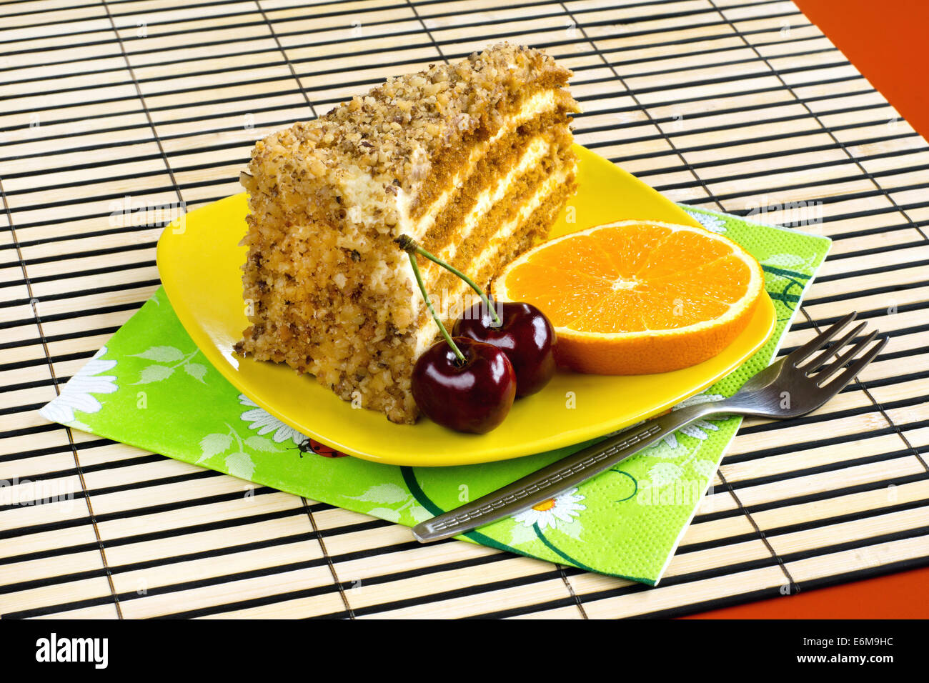Walnuss Kuchen mit einer Kirsche und einer Orangenscheibe garniert Stockfoto