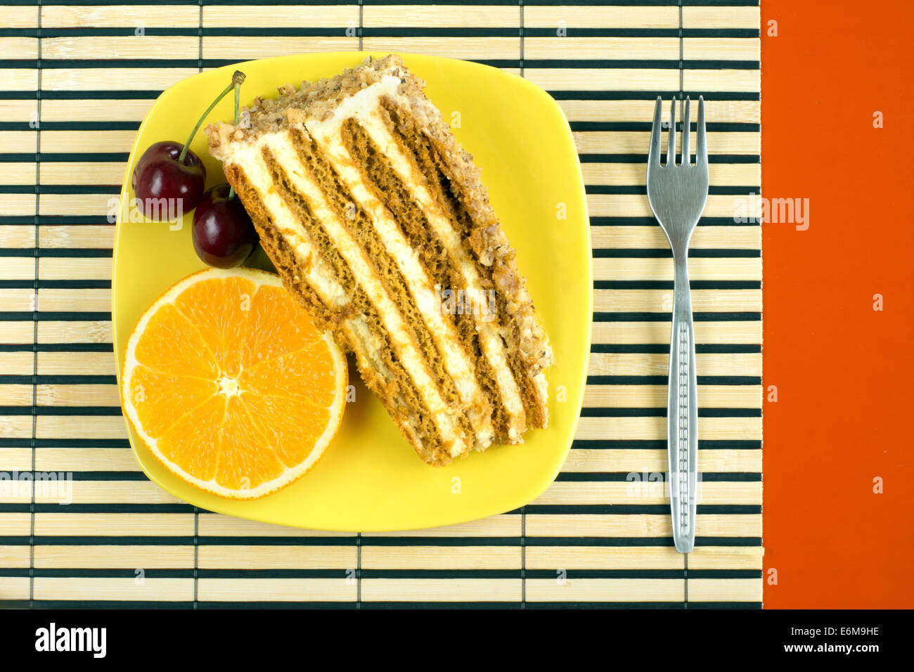 Nusskuchen, garniert mit einer Kirsche und orange slice Stockfoto
