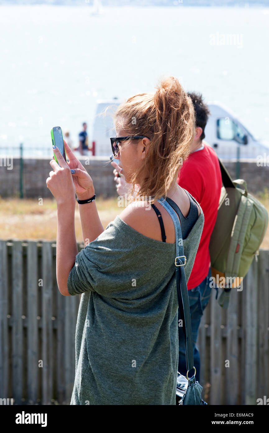 junge Frau, ein Foto auf ihrem Smartphone an die siegreichen Festival 2014 Southsea England uk Stockfoto
