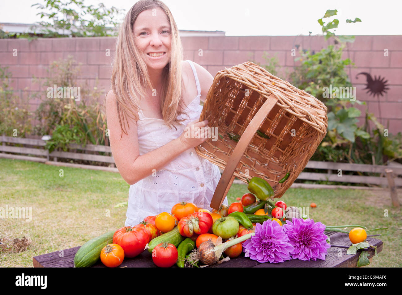 Blick auf Frau im Garten mit Korb mit Gemüse Stockfoto