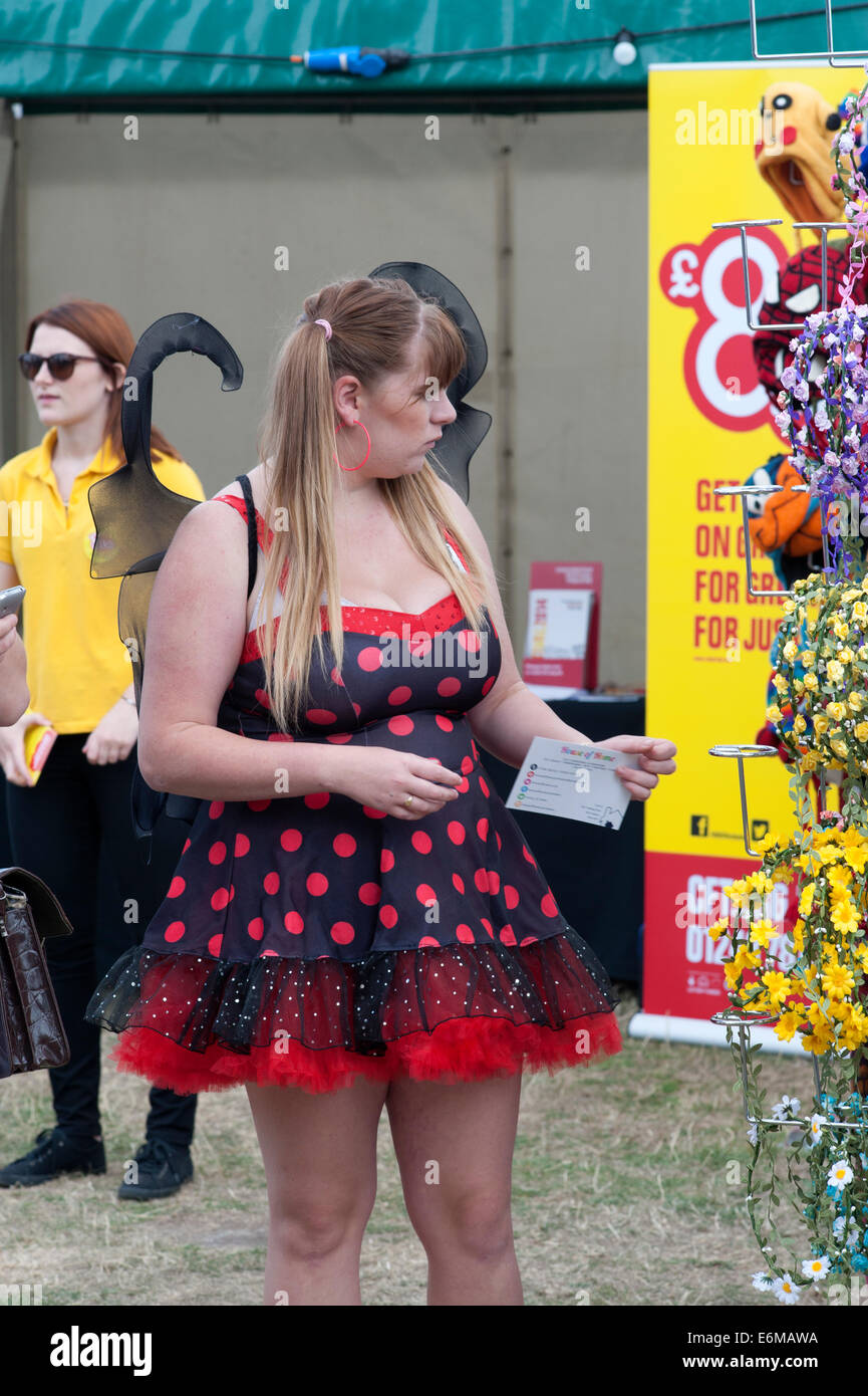 junge Frau, die Haare Blumengirlanden für den Verkauf an die siegreichen betrachten Festival 2014 Southsea England uk Stockfoto