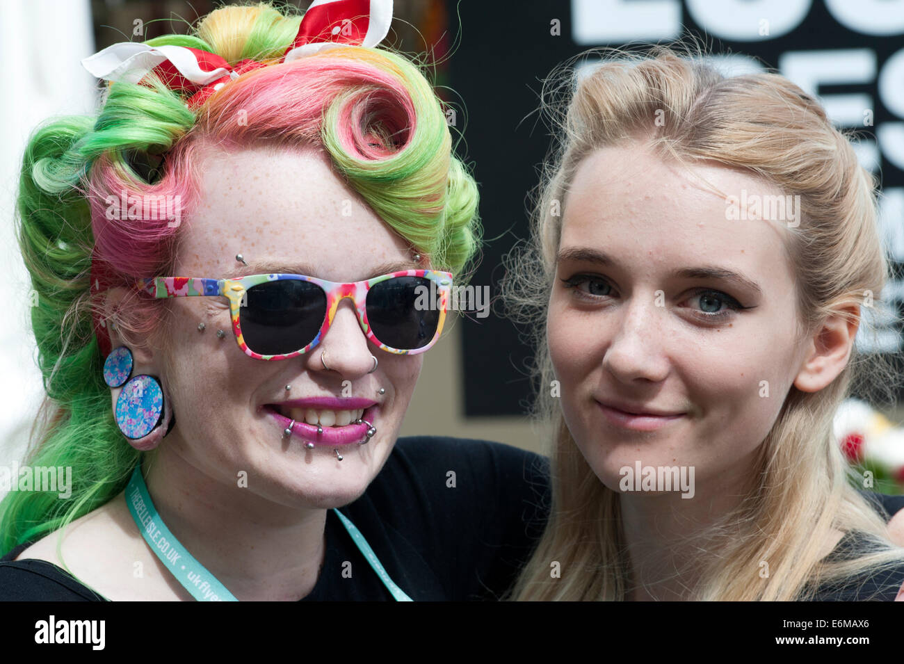 junge Frau mit Piercings und Multi coloriertes Haar mit Freund bei der siegreichen Festival 2014 Southsea England uk Stockfoto