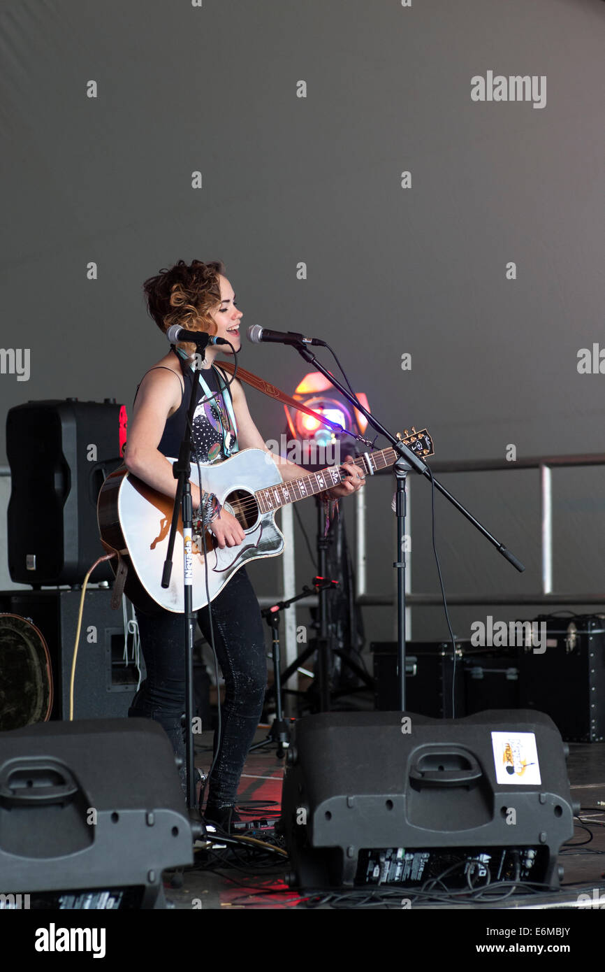 junge Frau singt und spielt Gitarre während auf Bühnen-Performance bei der siegreichen Festival 2014 Southsea England uk Stockfoto