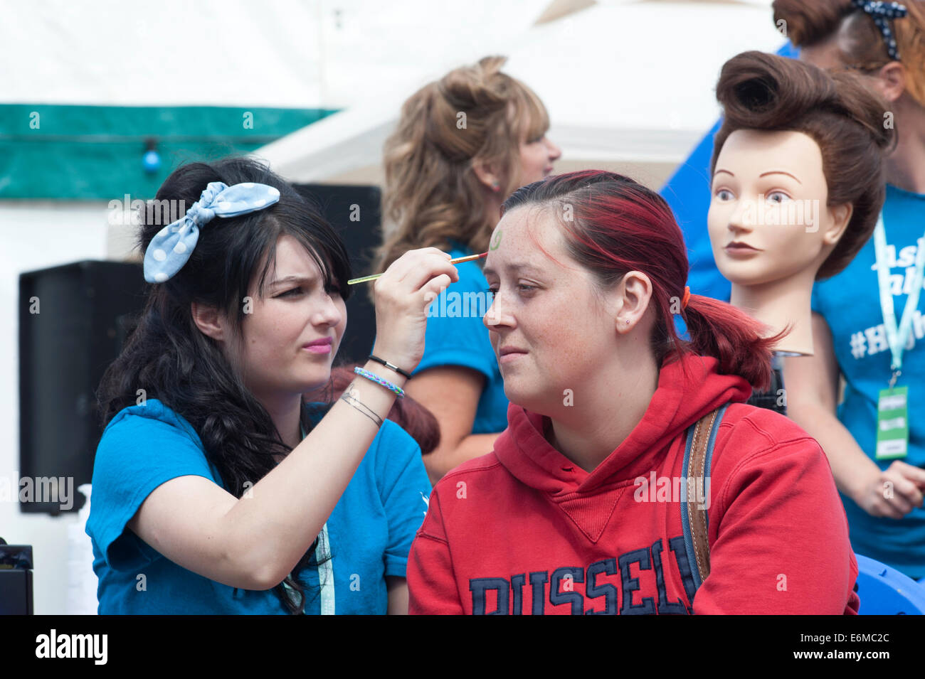 junge Frau, die ihr Gesicht gemalt an der siegreichen Festival 2014 Southsea England uk Stockfoto
