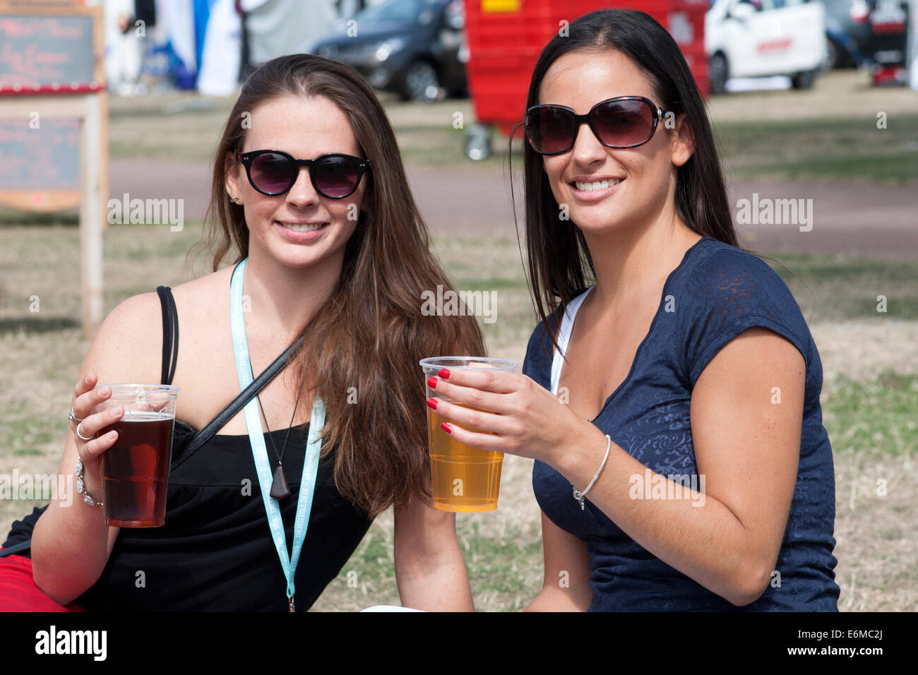 zwei hübsche junge Frauen genießen ein Bier an der siegreichen Festival 2014 Southsea England uk Stockfoto