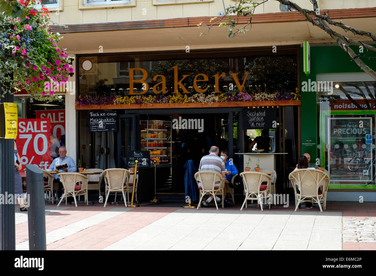 Kunden entspannen Sie bei Kaffee und Kuchen außerhalb einer unabhängigen Bäckerei in Palmerston Straße Southsea England uk Stockfoto