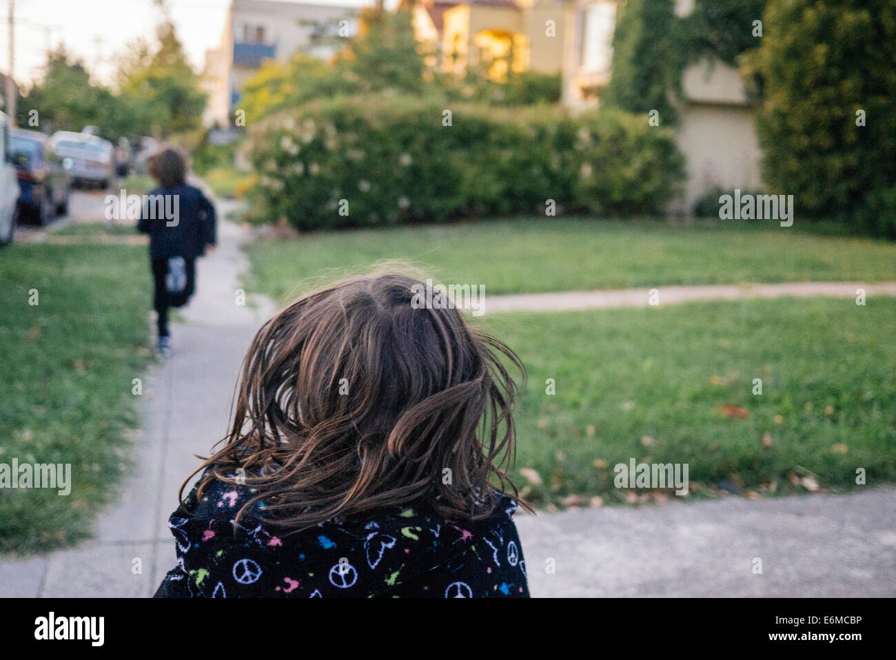 Mädchen läuft durch Nachbarschaft Stockfoto