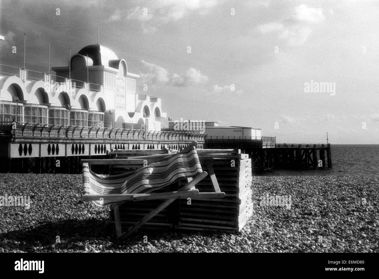 Liegestühle am Strand zusammen mit South Parade Pier schwarz-weiß Infrarot bei Southsea England uk Stockfoto