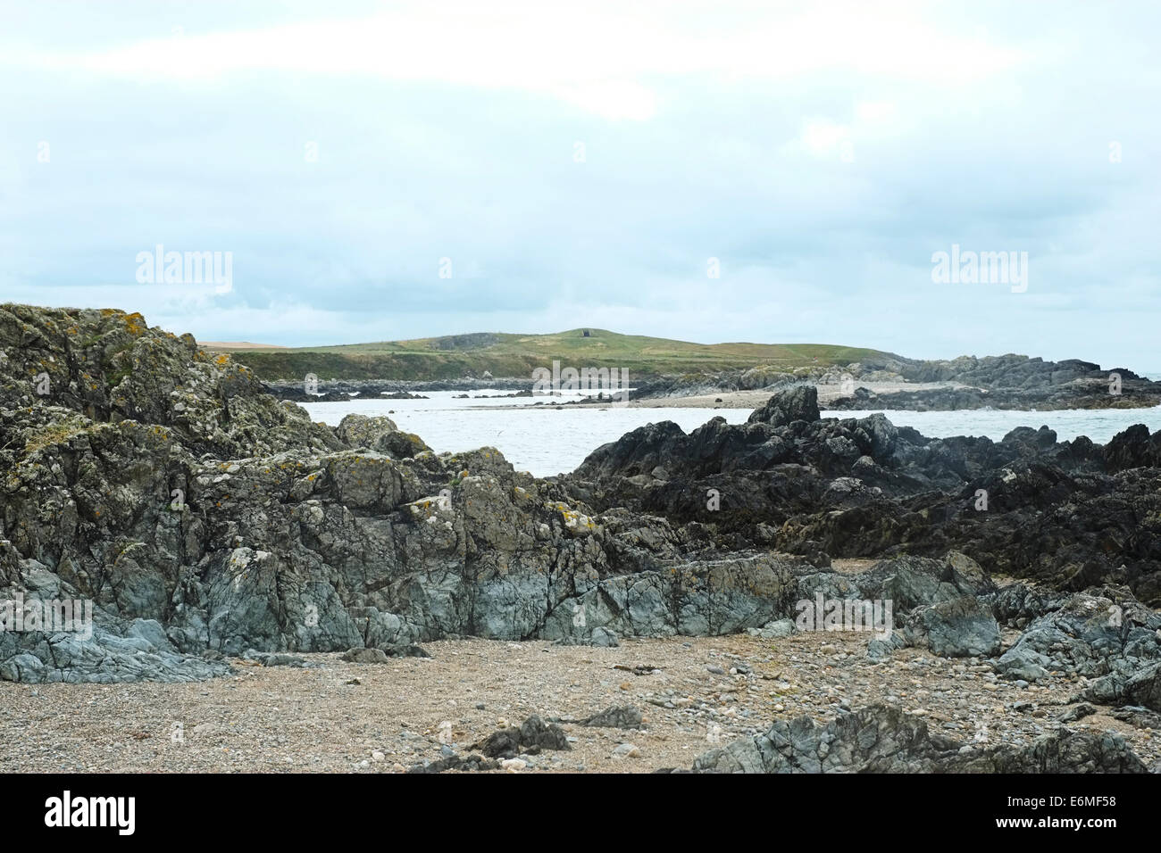 Blick über Meer und Felsen zum Begräbnis Kammer, Barclodiad y Gawres, Anglesey, North Wales, Mona Mam Cymru, Stockfoto